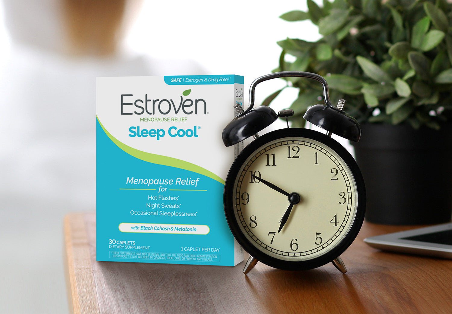 Estroven Sleep cool next to an alarm clock on a wooden table